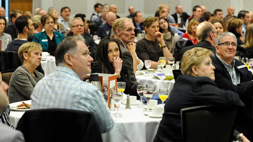 <who>Photo Credit: Lorne White/KelownaNow </who>Sarah Charles, centre, watches a video presentation with her parents, Jennifer and Gordy, during the induction gala.