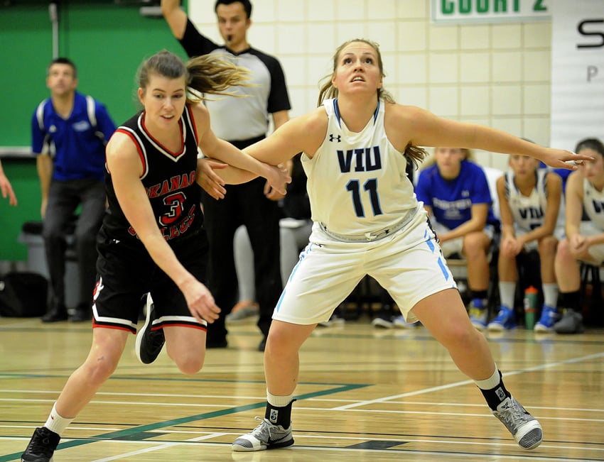 <who>Photo Credit: Lorne White/KelownaNow </who>Jenna MacLennan of the Coyotes, left, and KSS grad Kaitlyn Lafontaine of the VIU Mariners battle for position under the boards.