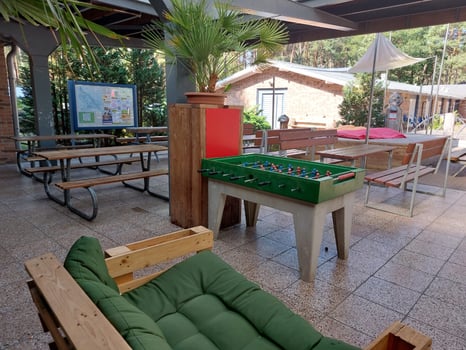 Überdachte Terasse mit Sitzgelegenheiten und Kickertisch