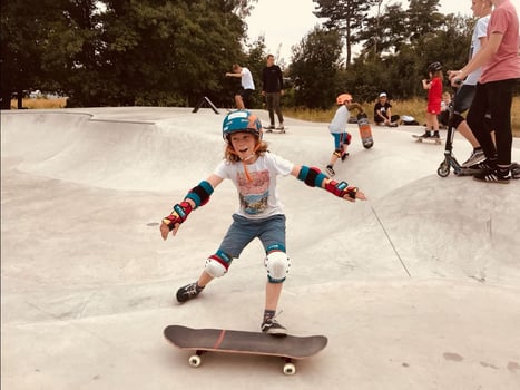Kind mit Schutzkleidung beim Skateboarden