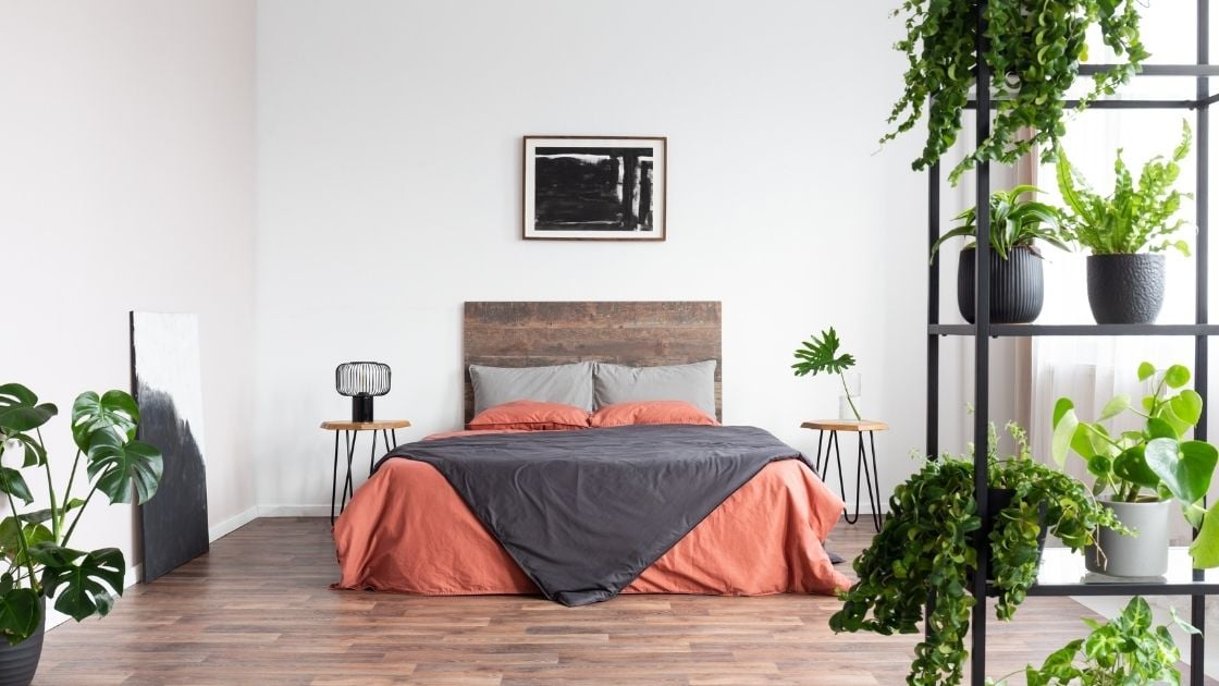 The many plants give this room an airy, spacious feel, while still being warm and inviting.  The headboard and the floor use wood to add to the rustic theme.