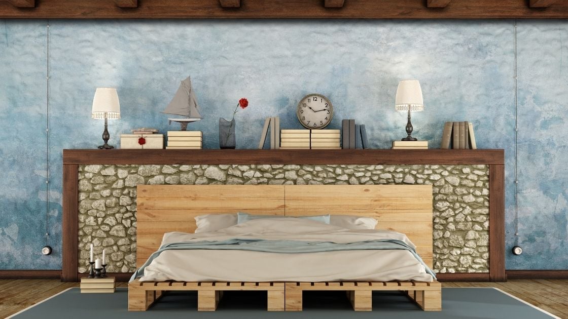 Set against the stone half-wall, the simple pallet style bed frame adds to the nautical feel.