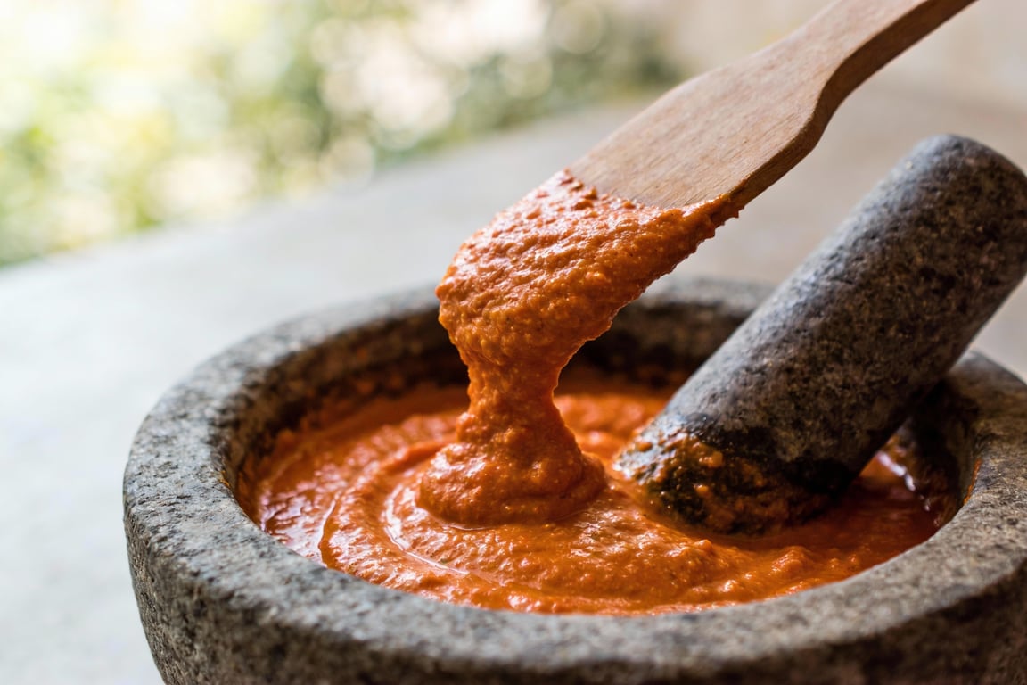 Crushed saffron threads being soaked to create a vibrant saffron fish broth for the stew