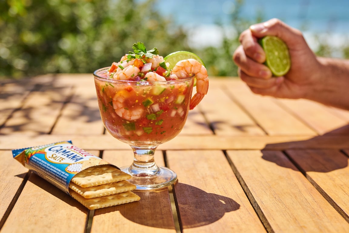 Mixing the Clamato shrimp cocktail with avocado and lime