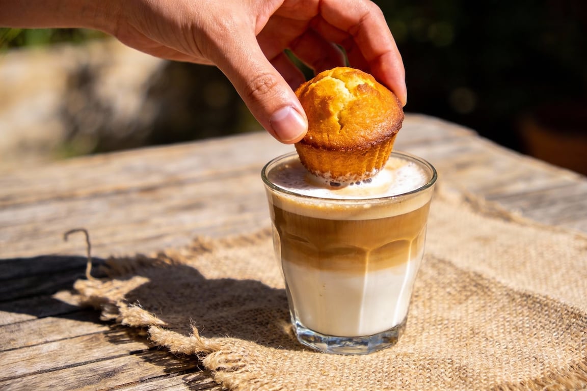 Dunking authentic olive oil muffins into cafe con leche