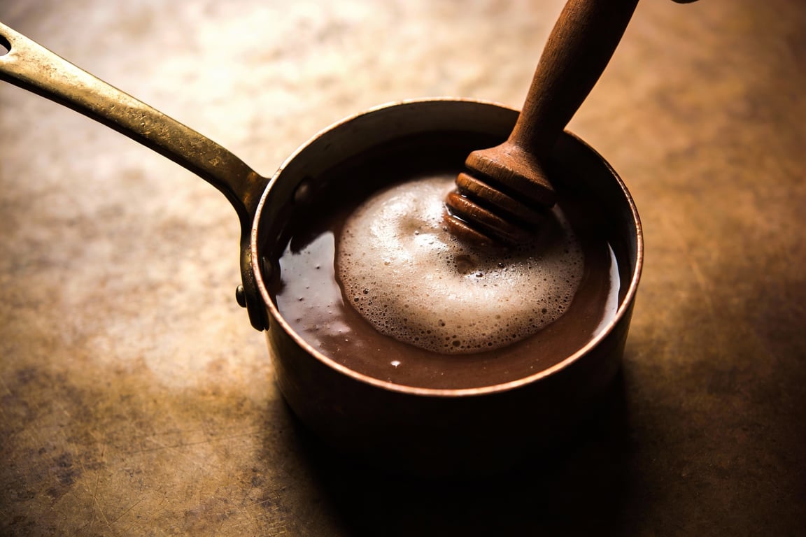 Using a molinillo to froth chocolate de mesa sauce