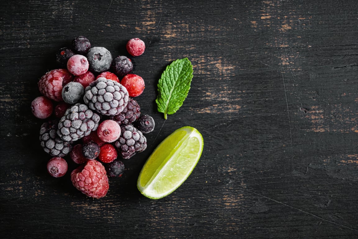 Frozen fruit ice cubes melting in a glass jar