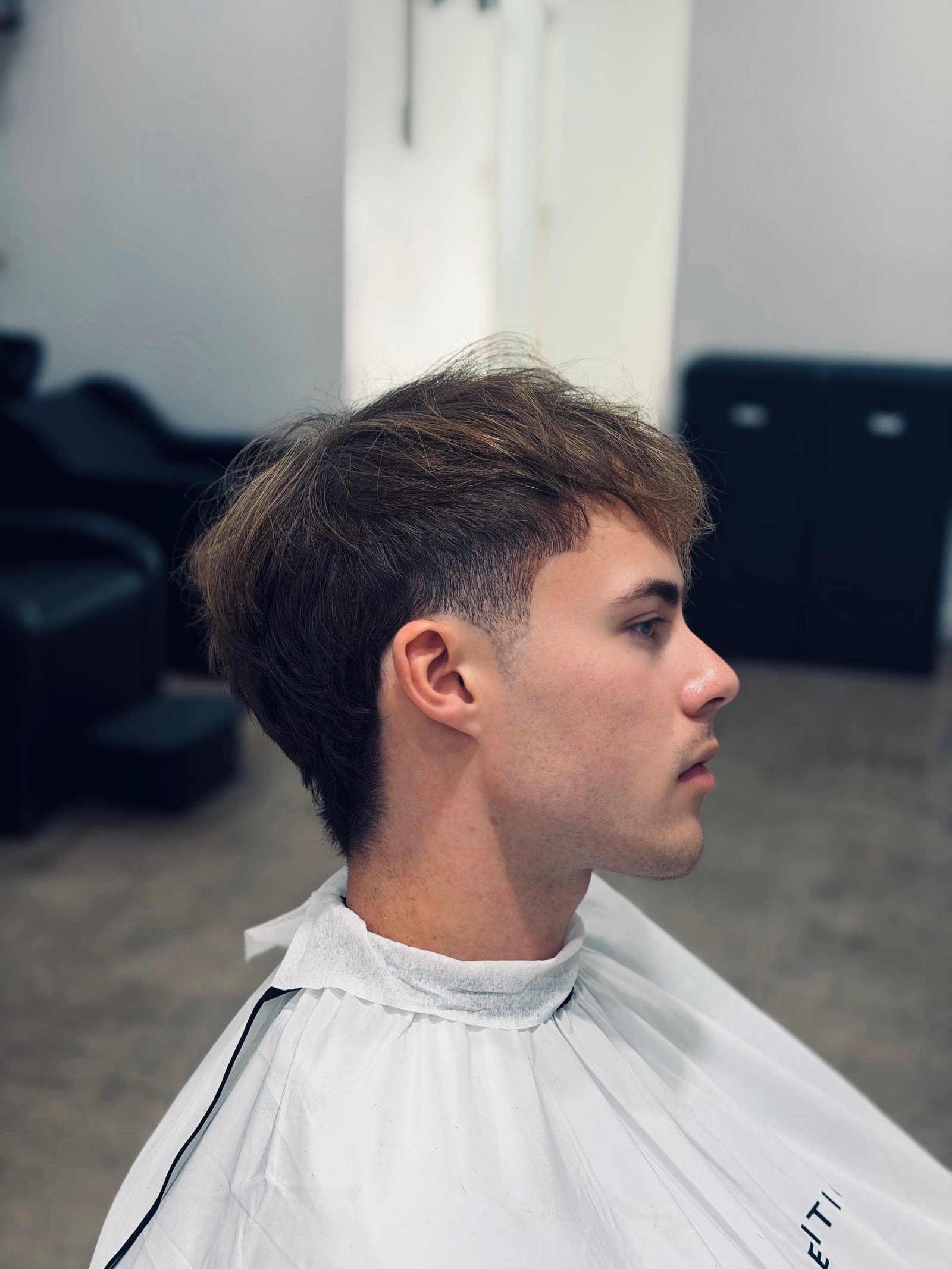 Stylish textured haircut with a clean fade and natural volume.