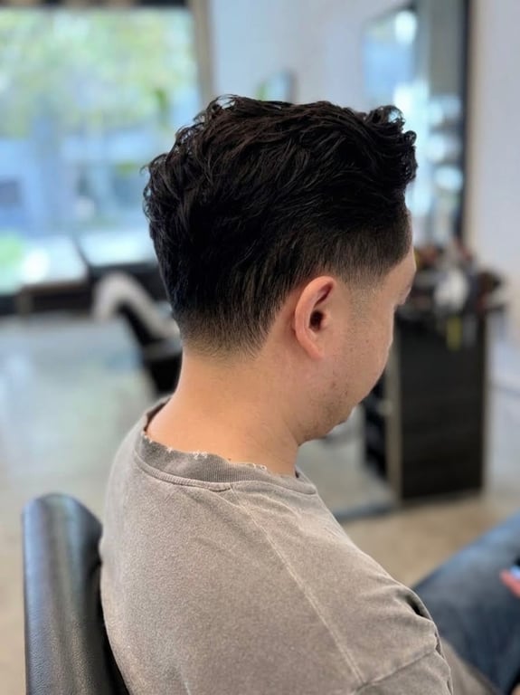 Textured haircut with a faded back and sides.