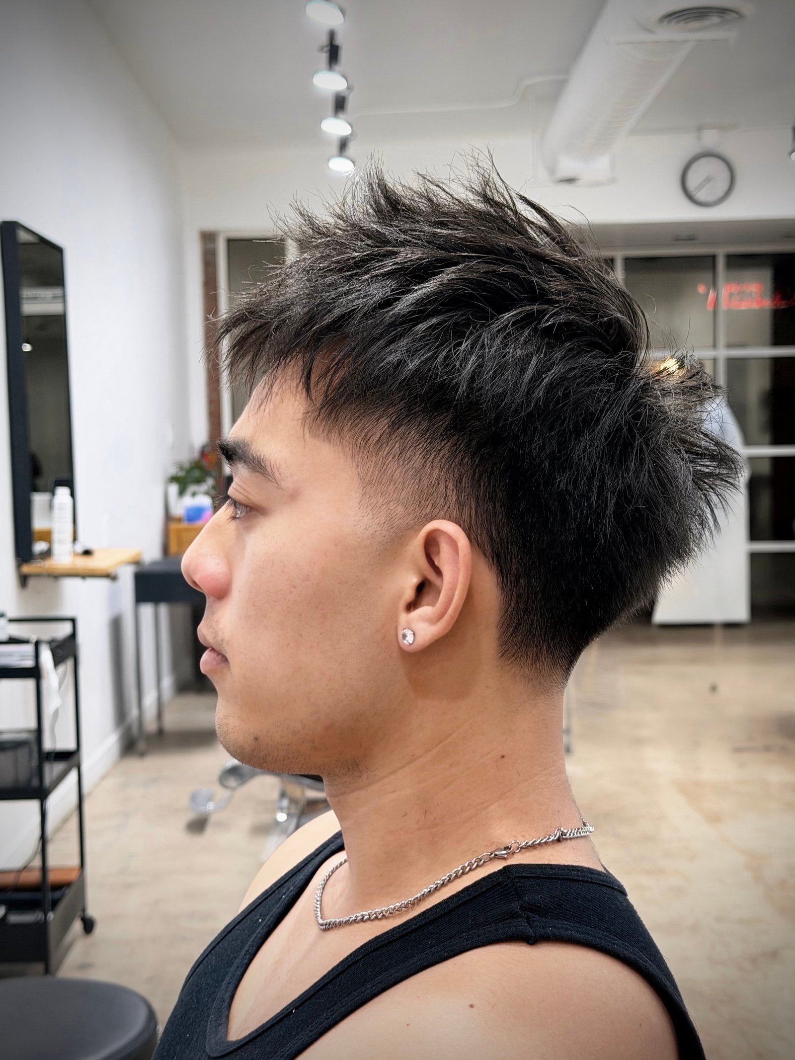 Textured hairstyle with a clean fade and defined edges.