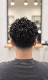 Curly textured haircut with a clean fade.