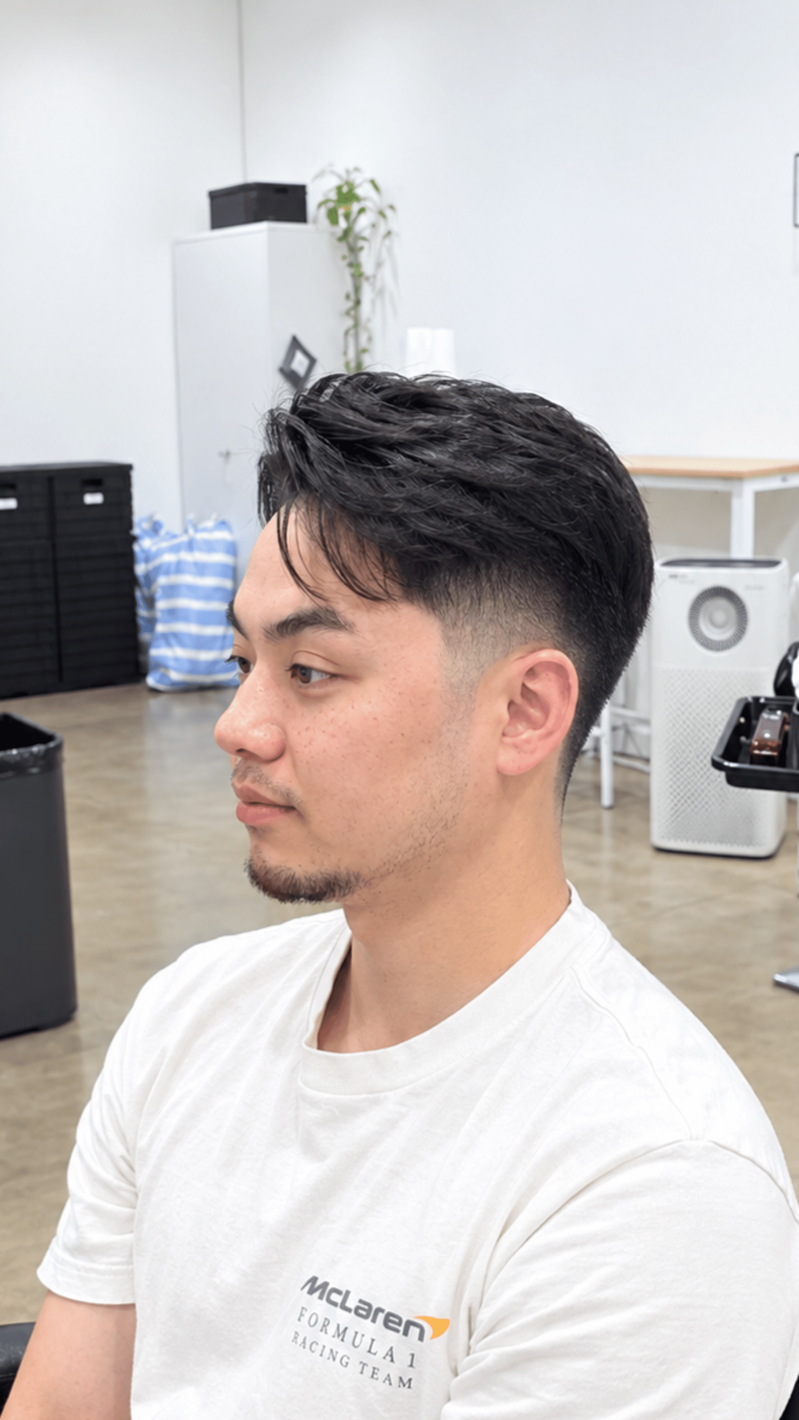 Stylish textured haircut with a clean fade and defined sideburns.