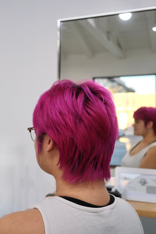 Vibrant pink layered haircut showcasing texture and movement.