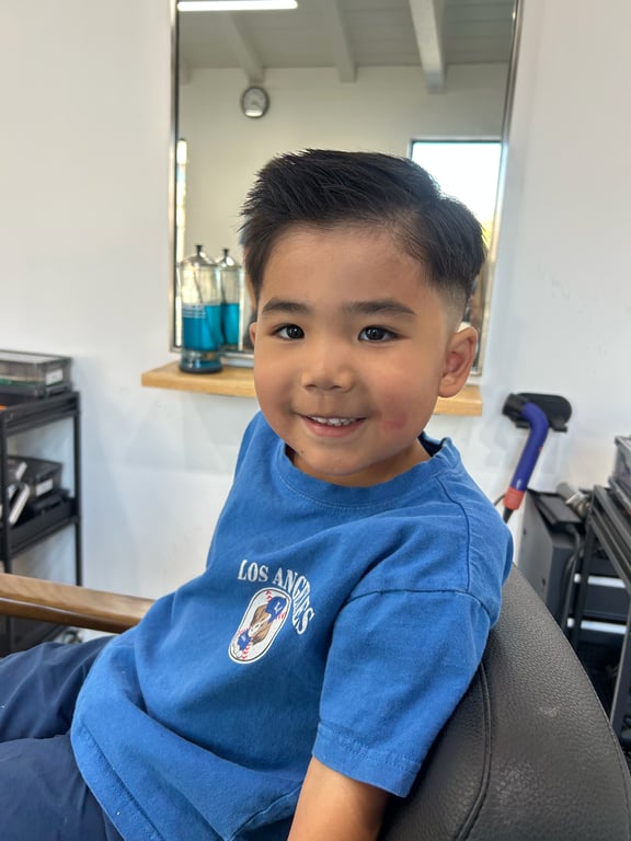 Classic boys' haircut with a neat side part and textured top.