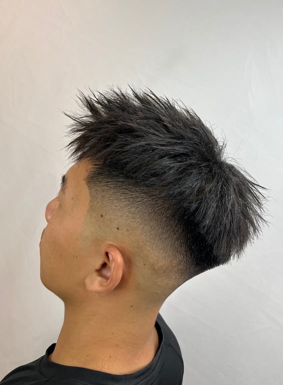 Textured hairstyle with a clean fade and volume on top.