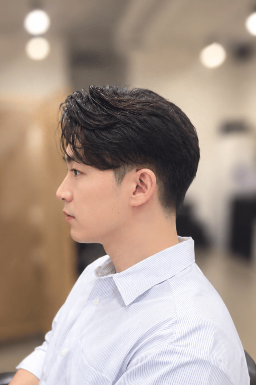 Stylish side profile showcasing a textured haircut with a clean fade.