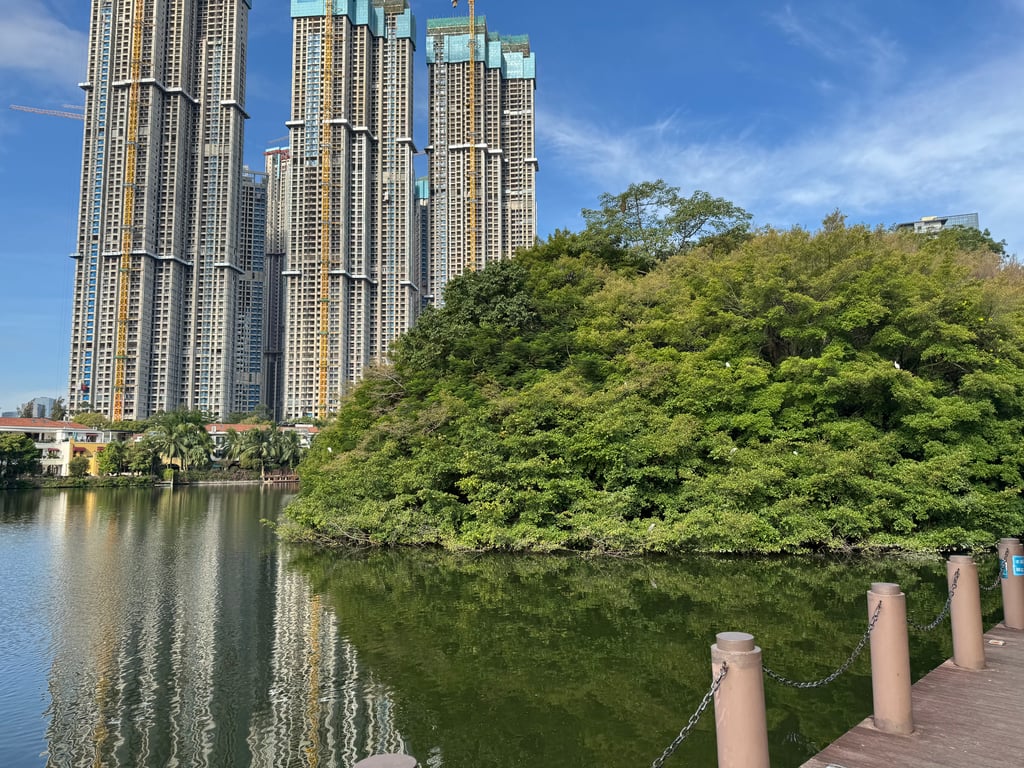 View of an apartment complex in Shenzhen from outside a restaurant by a pond.