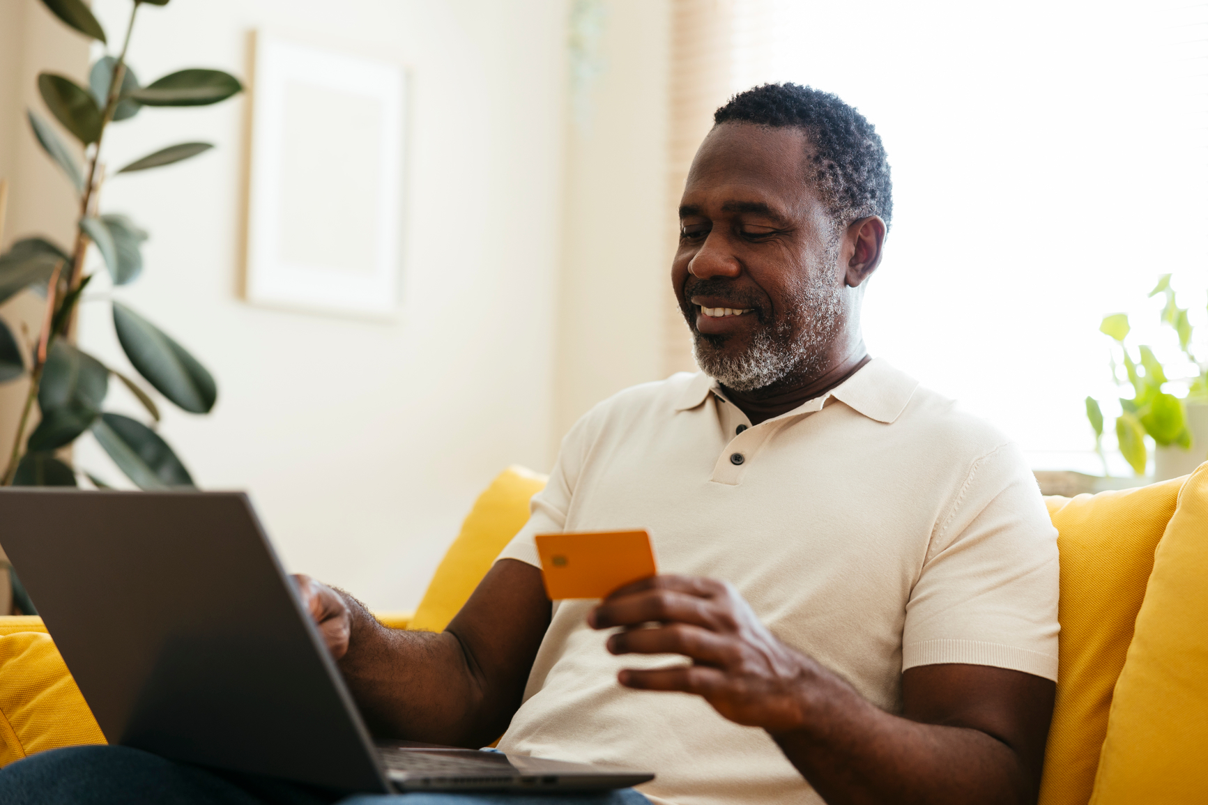 Man at a computer holding a credit card.