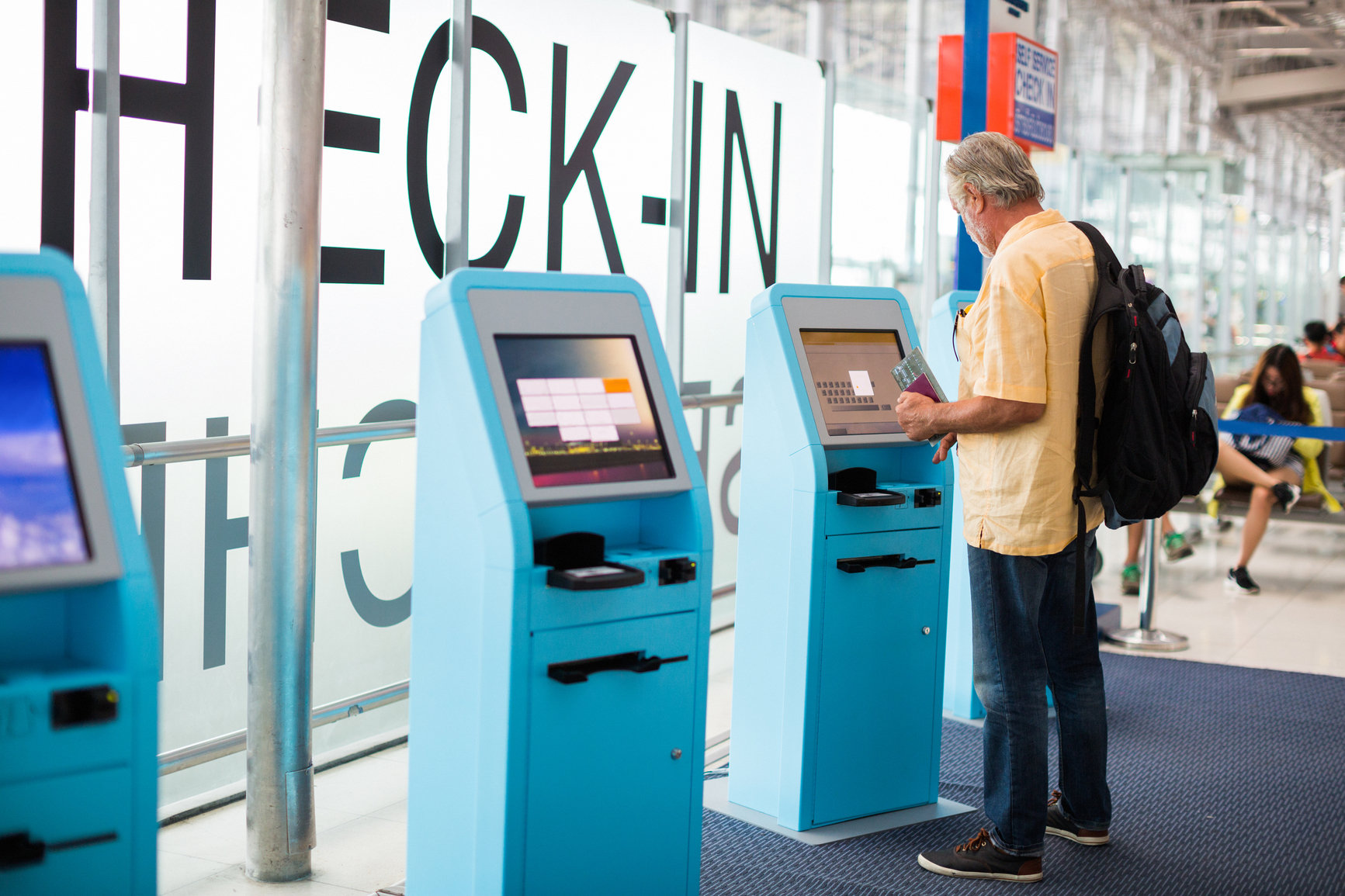 Man checking in at a ticketing kiosk