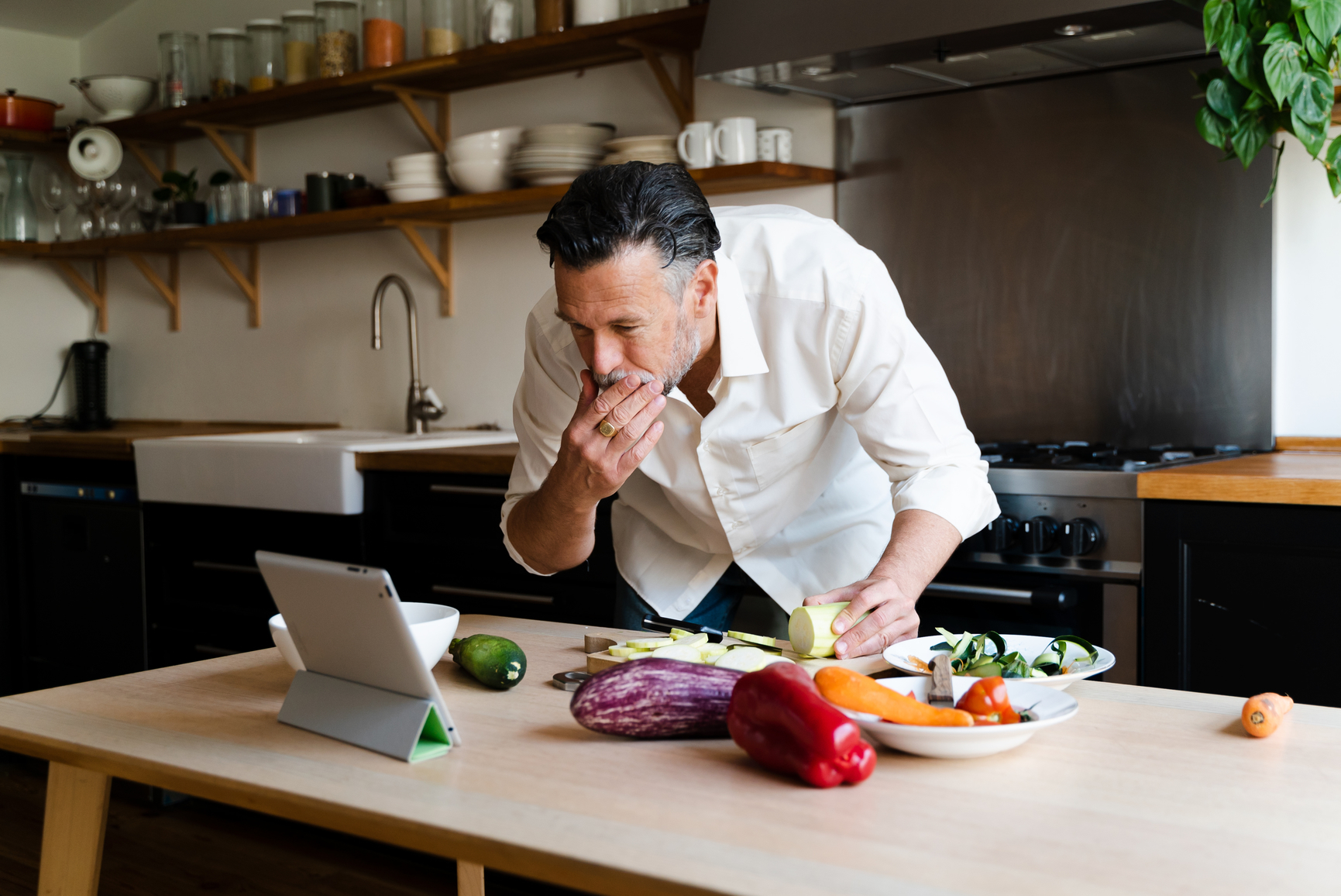Man using a tablet to follow a recipe.