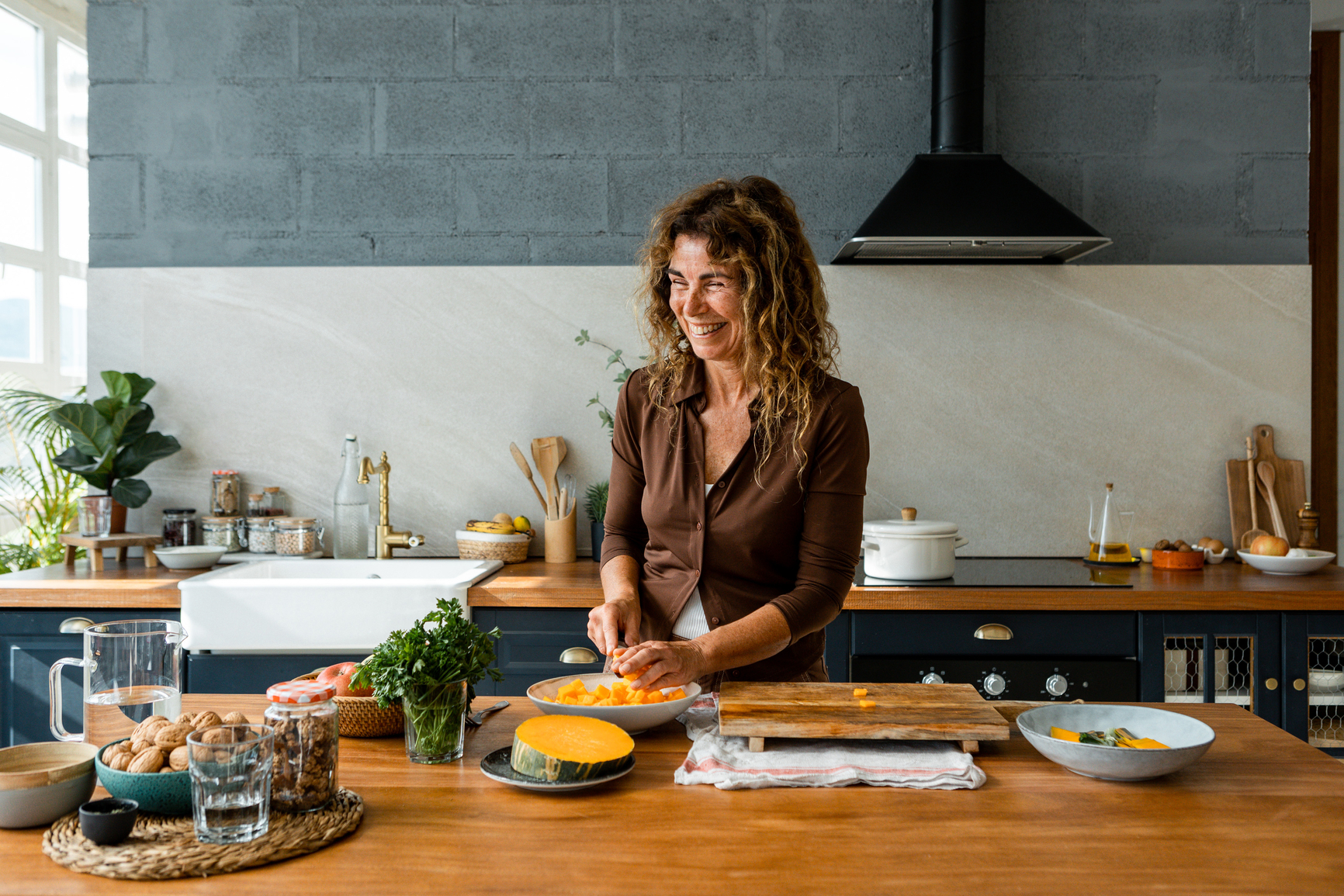Woman preparing squash and parsley for a recipe.