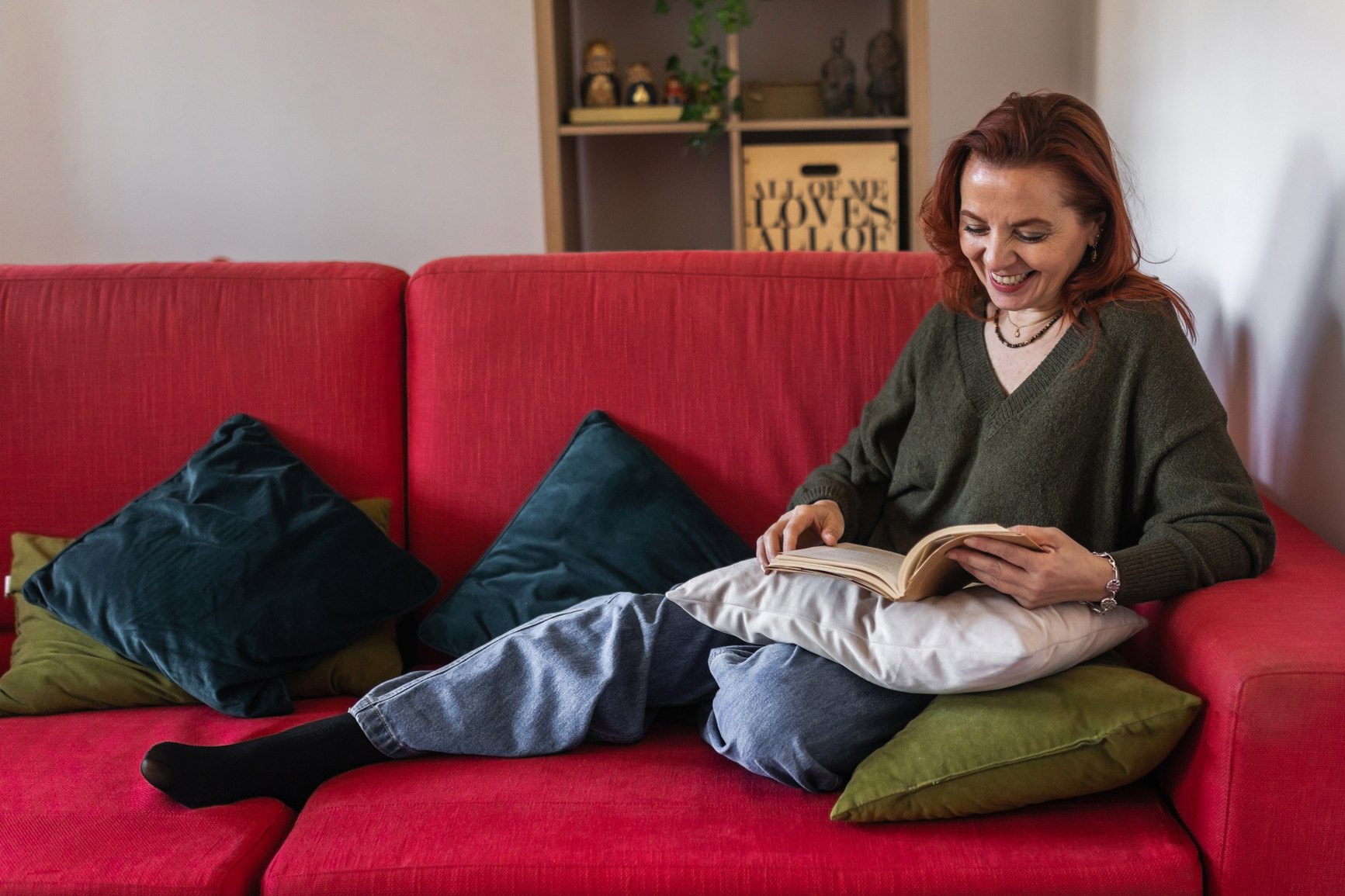 woman sitting on a couch, reading a book