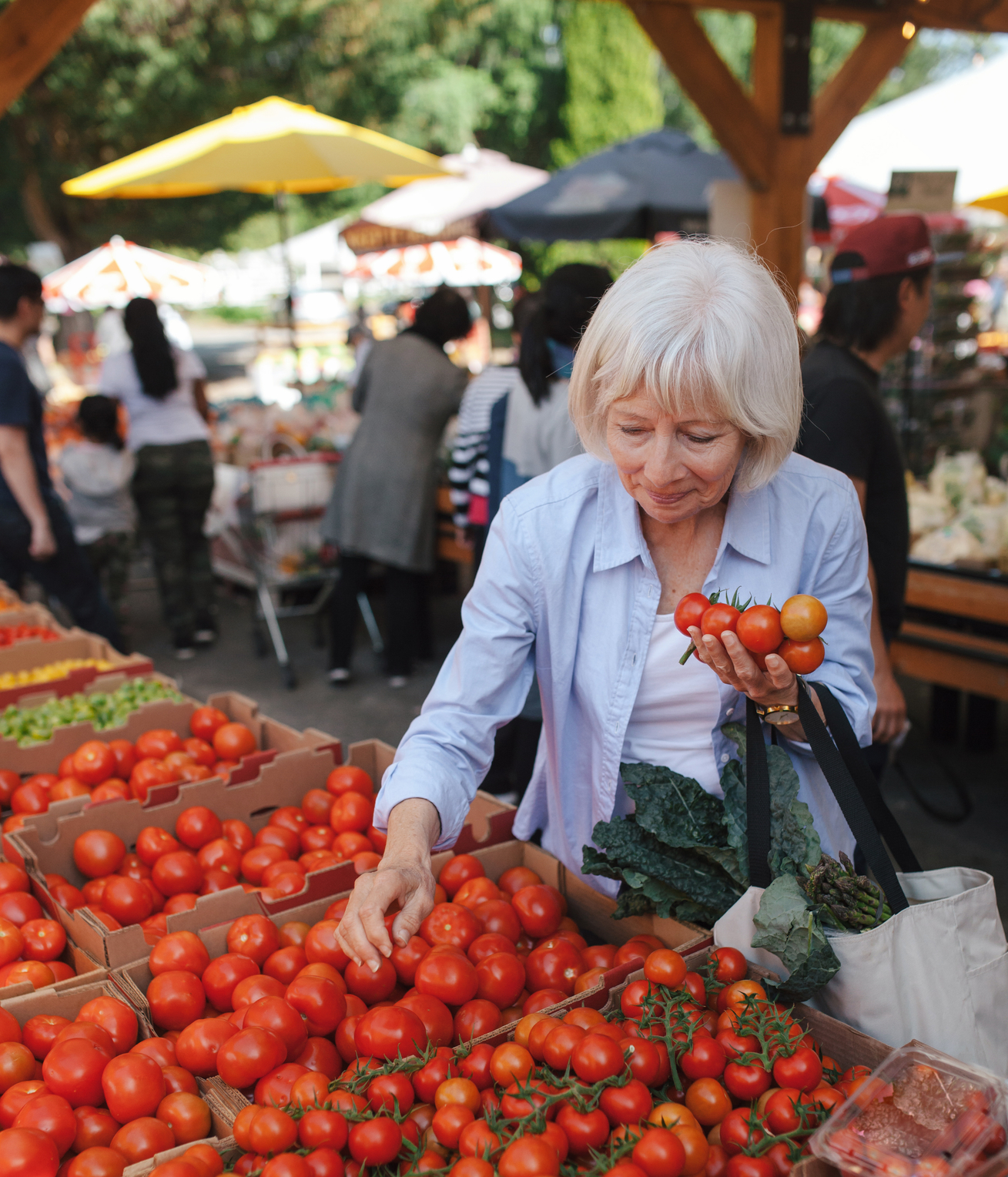 Woman sampling tomatoes at a farmers market.