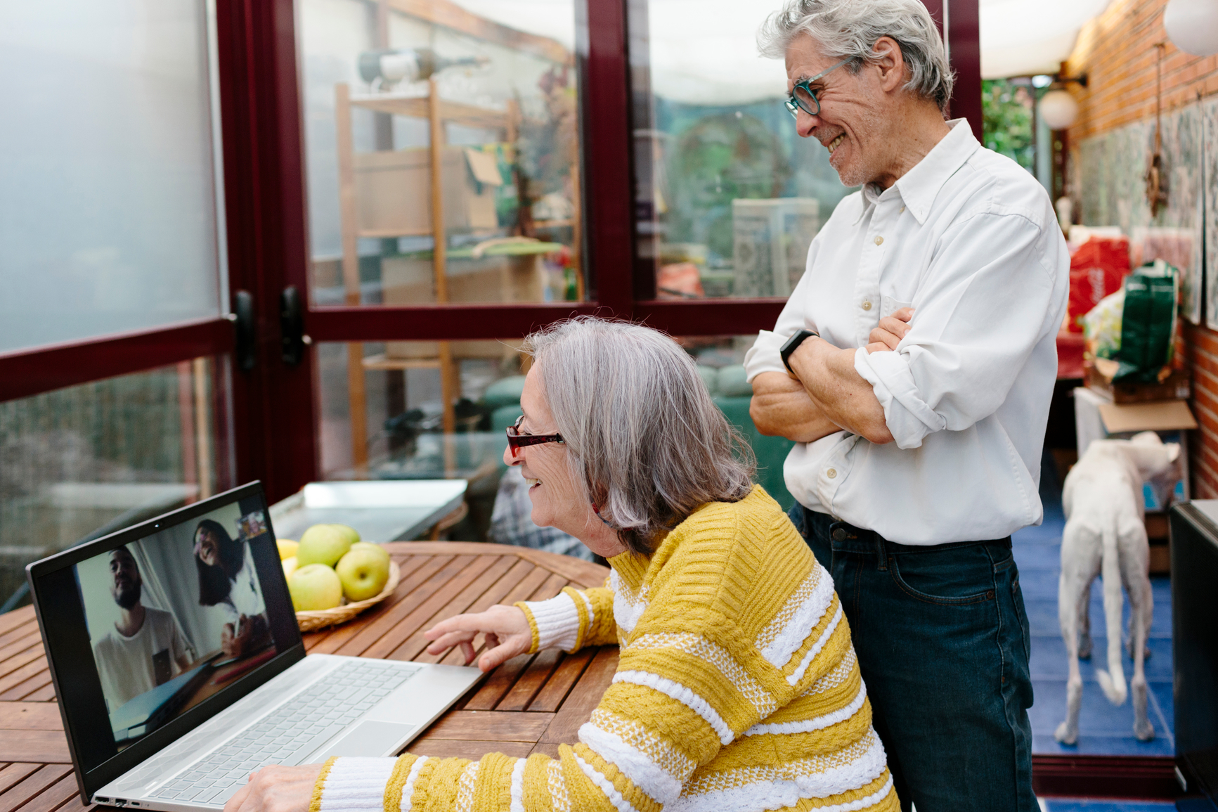 Couple on a video call at their computer.