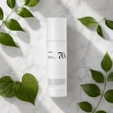 Anua Heartleaf 70 Lotion on surface with green botanical elements