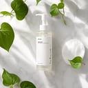 Anua Heartleaf Cleansing Oil on surface with botanical elements