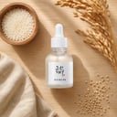 Beauty of Joseon Glow Deep Serum with rice grains and barley on linen surface