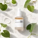 Anua Heartleaf 80 Ampoule on surface with green leaves