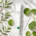 Skin1004 Tea-Trica Spot Cream on surface with tea tree and centella elements