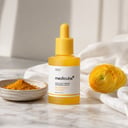 Medicube Kojic Acid Turmeric Niacinamide Serum on white marble vanity