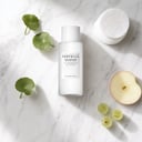 Skin1004 Tone Brightening Boosting Toner on surface with cotton pads and fruit