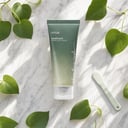 Anua Heartleaf Pore Clay Pack on surface with green elements