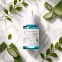Axis-Y Artichoke Ampoule on surface with botanical elements