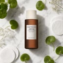 Skin1004 Probio-Cica Essence Toner on surface with cotton pads and centella