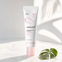 Medicube PDRN Pink Tone Up Sun Cream on marble surface with water droplets
