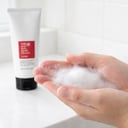 Hands lathering COSRX Salicylic Acid Cleanser into rich foam