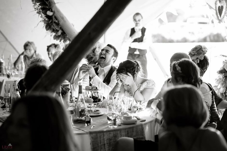 Bride and groom laughing at speech