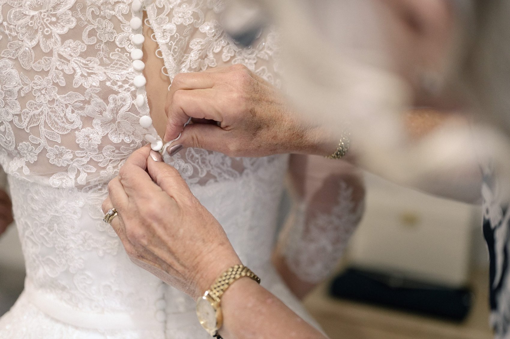 fastening the wedding dress at Highcliffe castle wedding