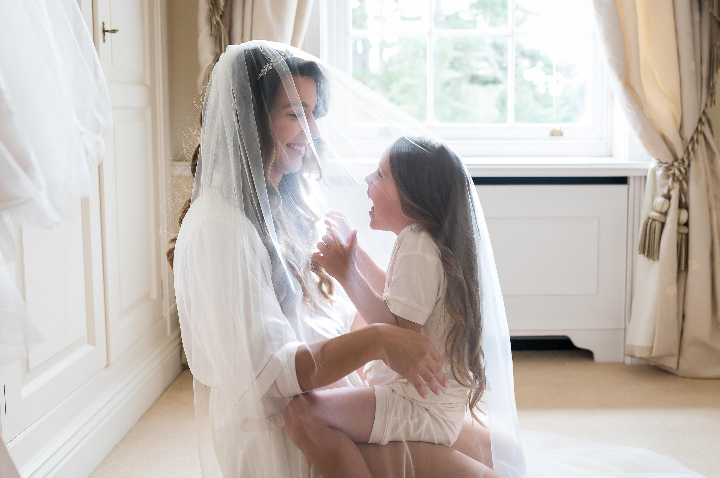 Bride and her daughter laughing under the veil