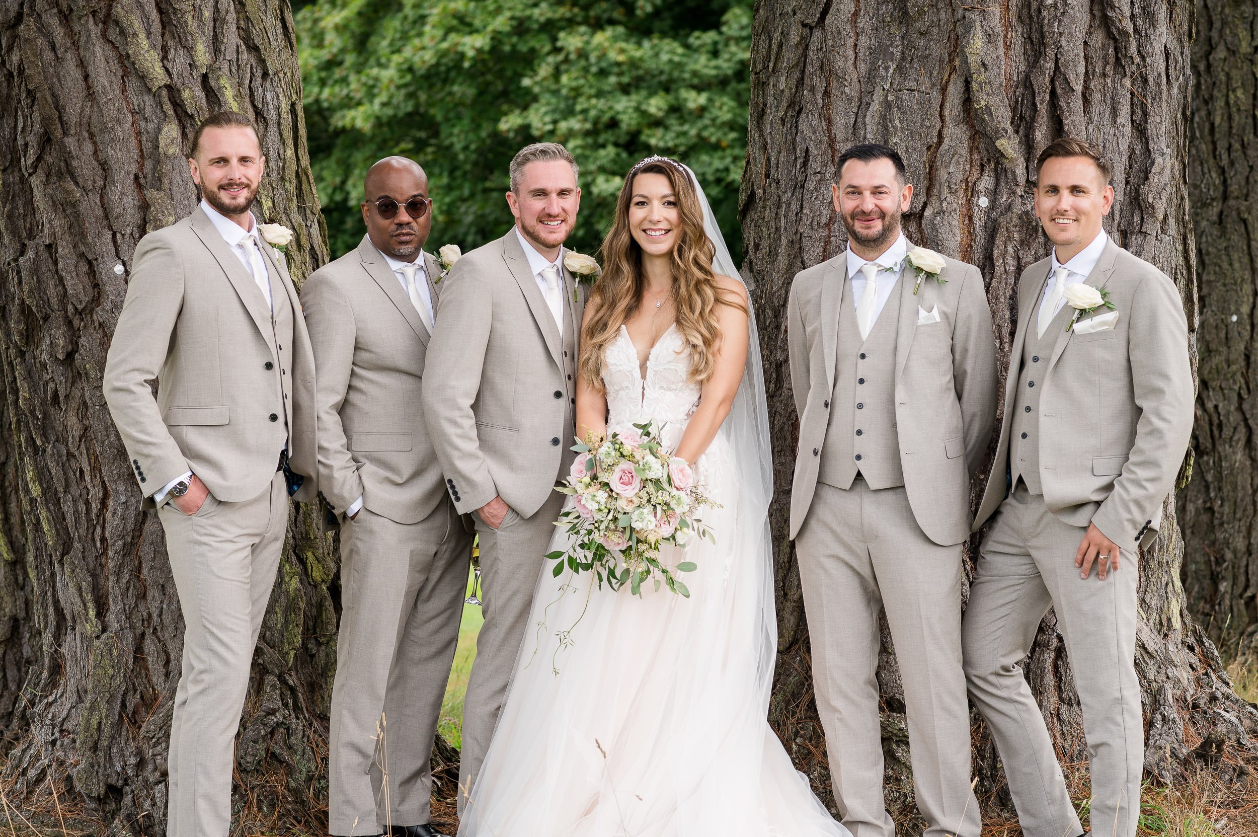 Bride with all the groomsmen at Hethfelton House wedding - Formal group photo