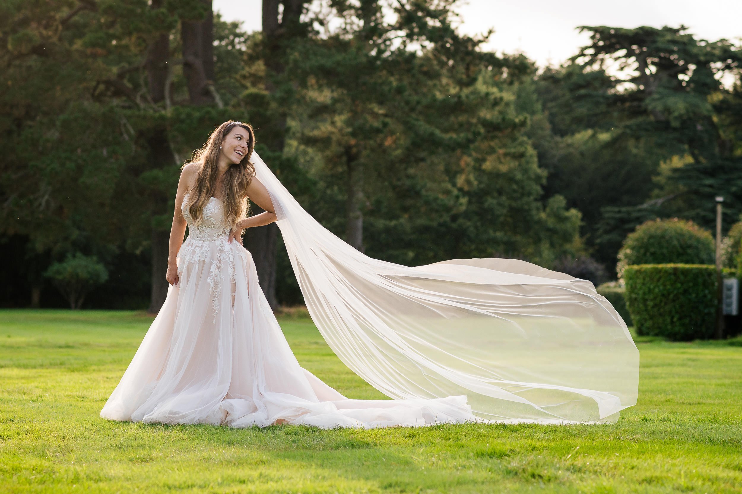 Bride in the garden at Hethfelton House wedding as her veil catches the wind