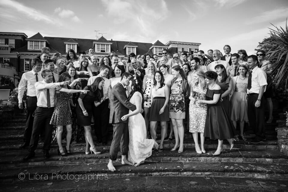 bride and groom kiss in front of friends at Miramar Hotel