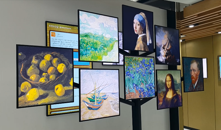 Angled wall of high-brightness displays showing classical paintings