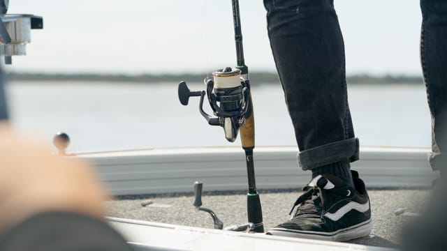 A spinning rod standing on the casting deck between fish
