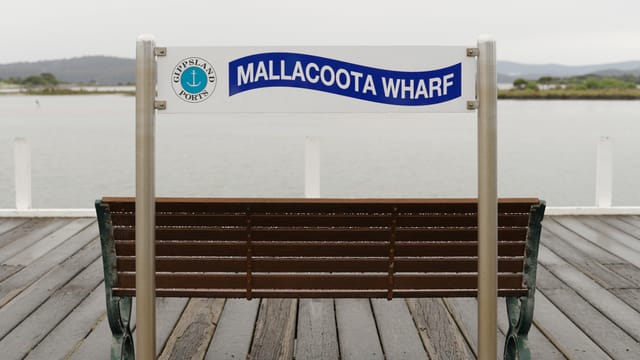 The Mallacoota Wharf sign on a wet grey morning