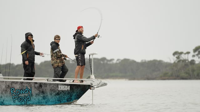 A cast arcs off the bow in the mist, rod fully loaded